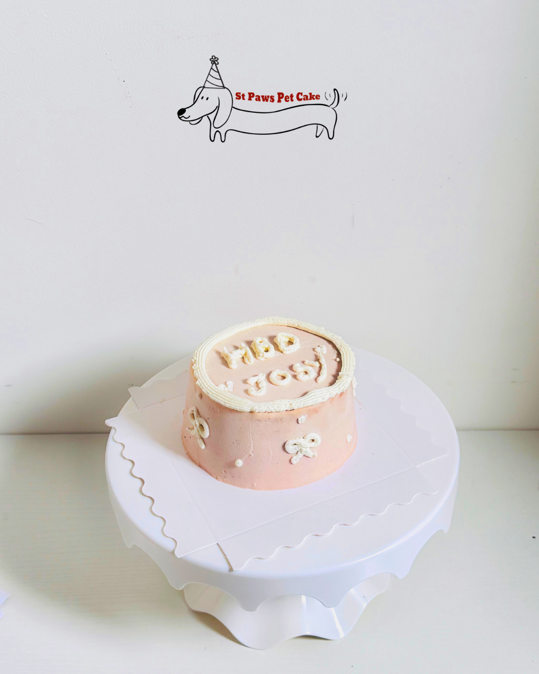 Salmon fillet pink customisable pet birthday cake with white cream and girly ribbon hand pipped